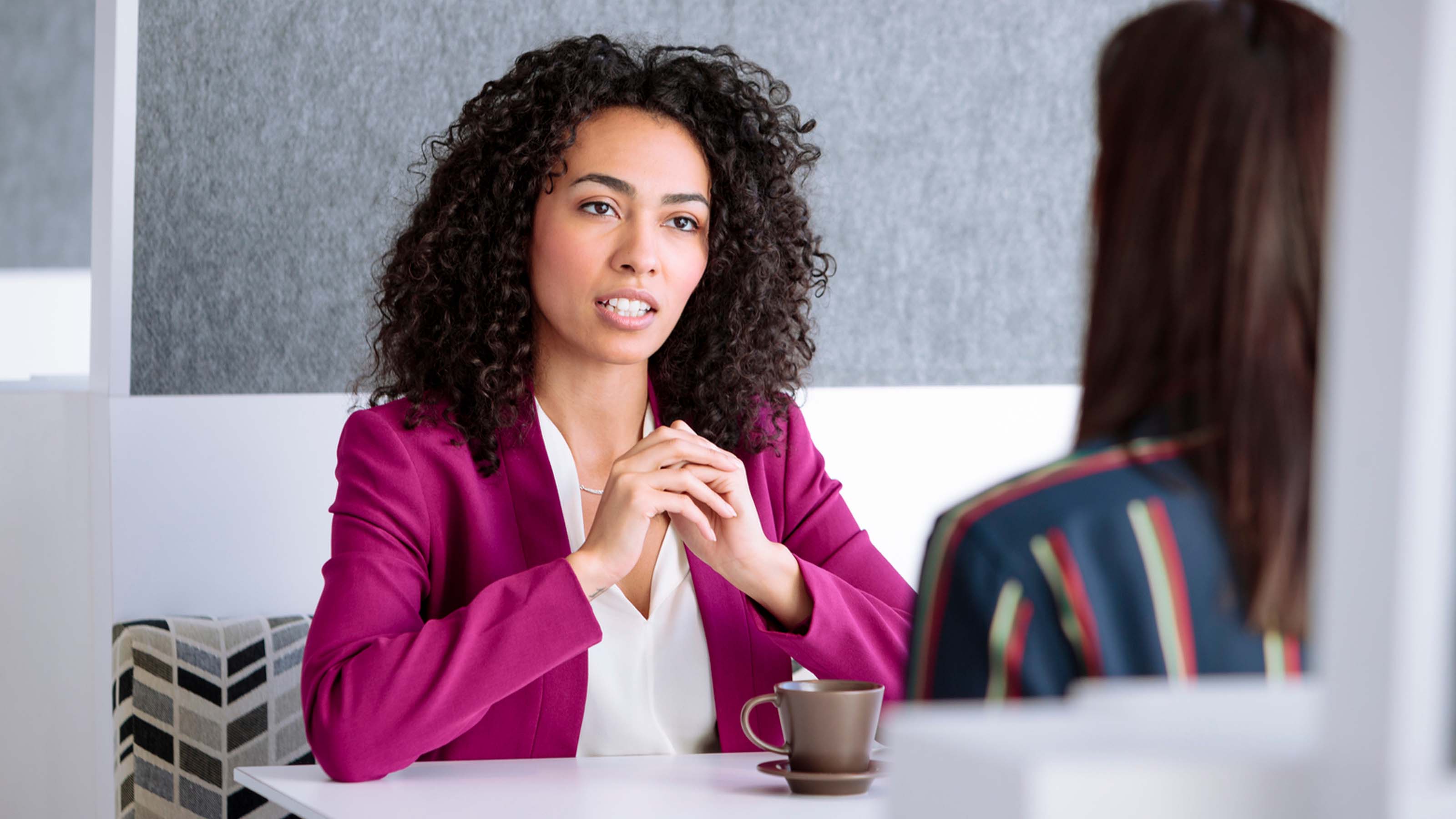 Two women meeting in an office cafe.