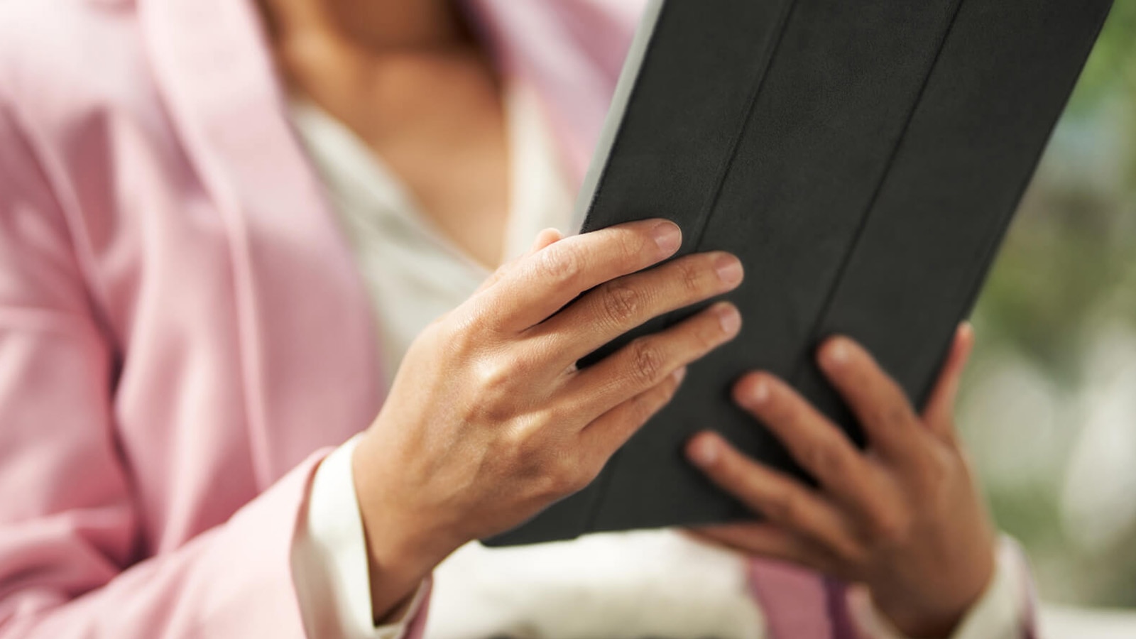 Close-up on hands, holding a tablet.