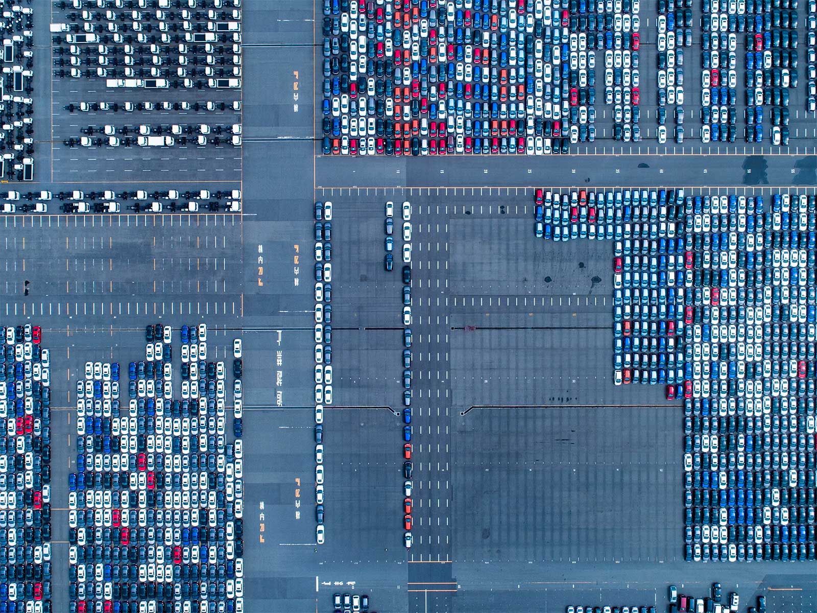 This arial view of a vast parking lot illustrates the concept of data management: collecting, storing, utilizing data with security, efficiency, cost-effectiveness.