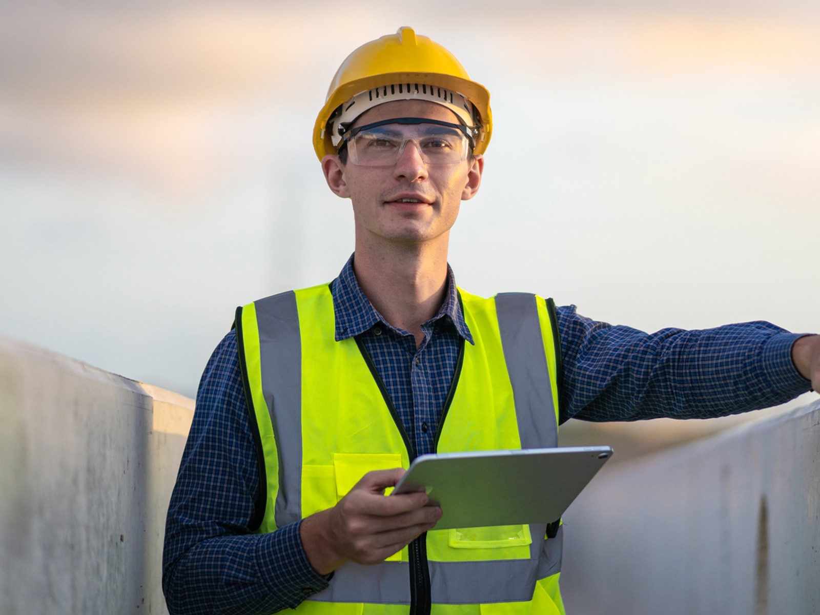 Ein Ingenieur mit einem Tablet prüft die Qualität von Beton auf einer Großbaustelle.