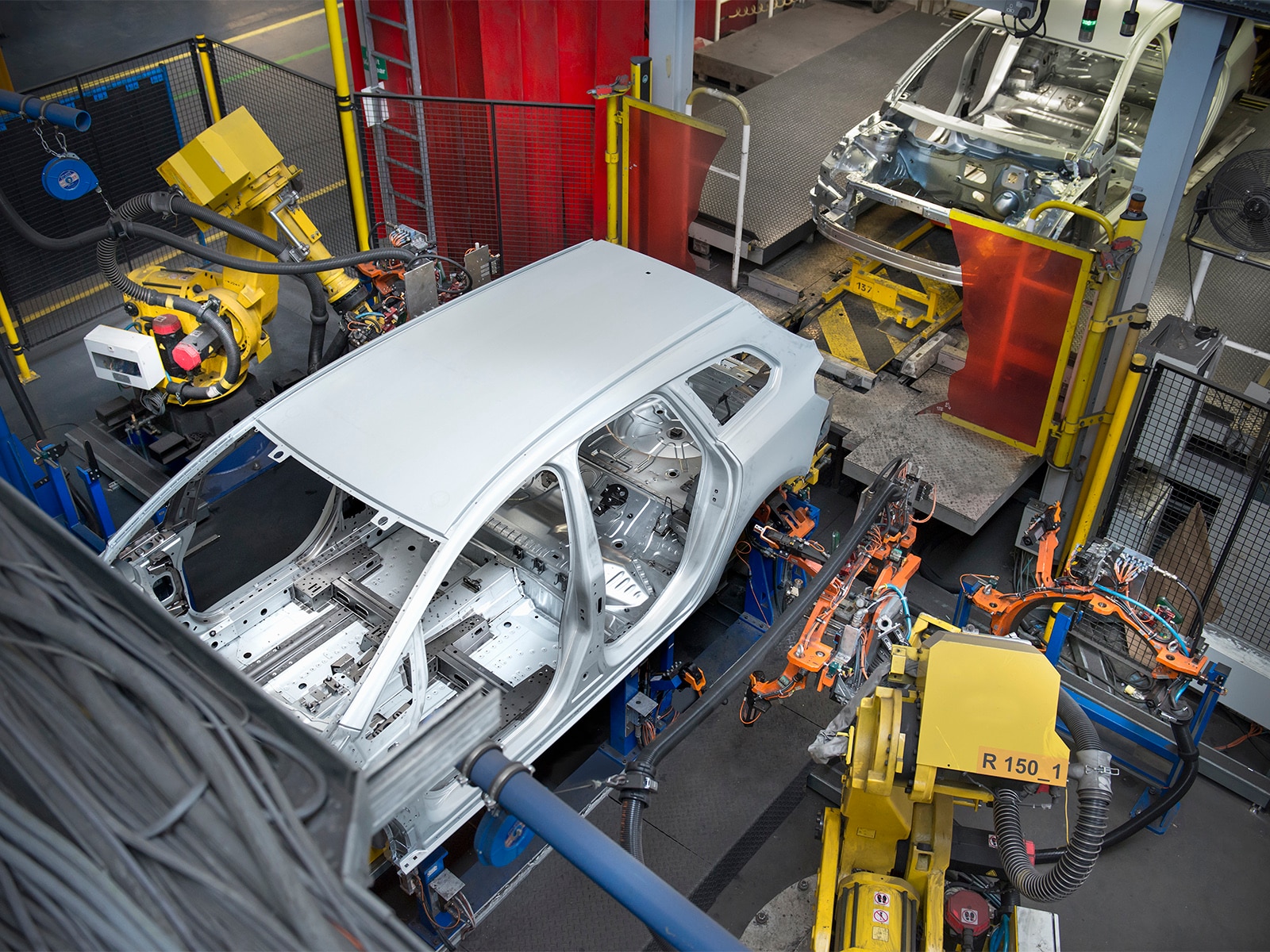 Car being built in a automated factory.